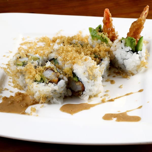 Tsunami Panhandle's crispy shrimp tempura sushi rolls with avocado, topped with golden crumbs and sauce.